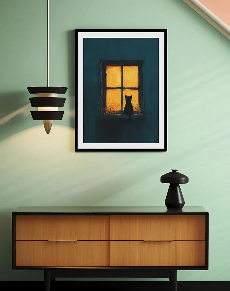 A silhouette of a cat gazing out of a warmly lit window on a quiet night. Perfect wall art for creating a cozy and peaceful ambiance