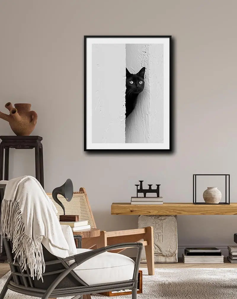 A minimalist black and white photograph of a black cat peeking around a textured wall, capturing its curious expression and striking eyes. Ideal for wall art or poster decor