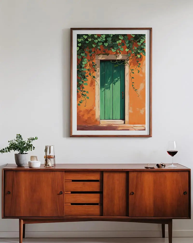 A charming green door surrounded by lush vines on an orange wall. Perfect wall art for adding a touch of rustic charm and warmth to any room, evoking a Mediterranean feel.