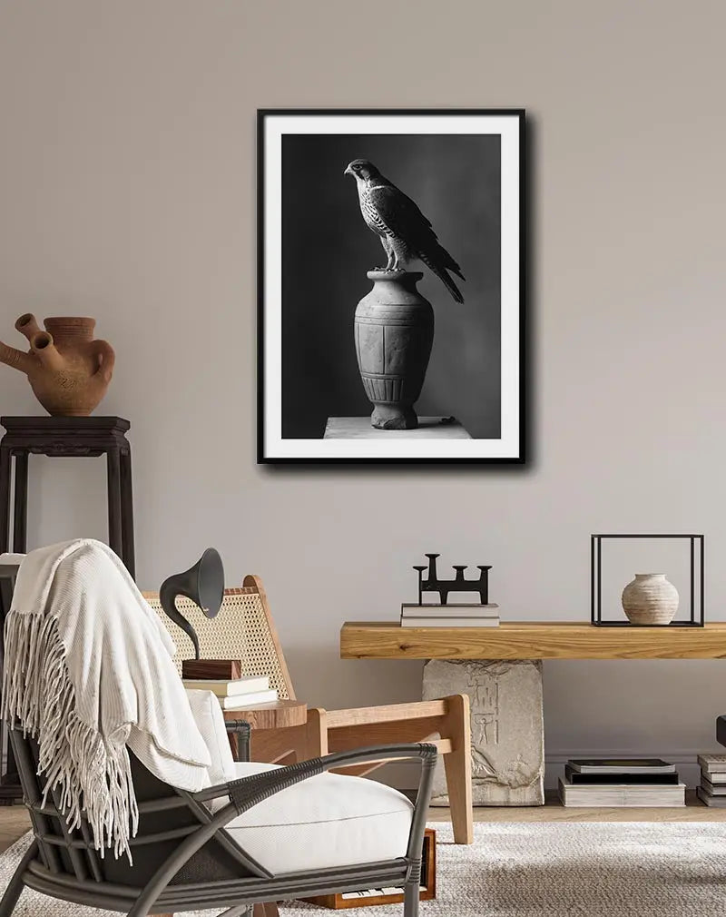 A stunning black and white photograph of a falcon perched gracefully on a stone vase. Perfect wall art or poster for creating a sense of calm and majesty in any space