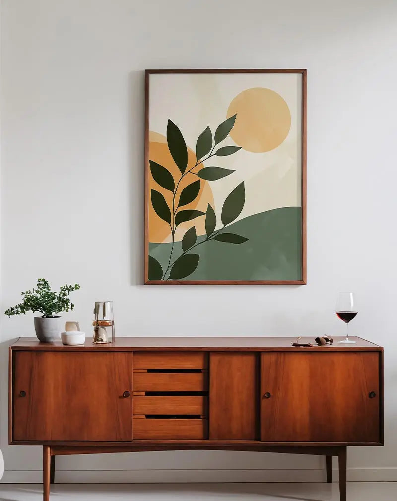 An abstract illustration of green leaves against an orange sun, creating a minimalist and modern design. Perfect wall art for a contemporary touch.