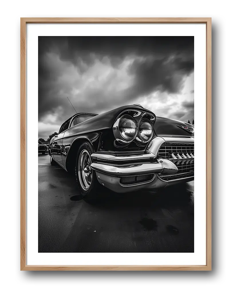 A stunning black and white photograph of a vintage classic car with dramatic clouds in the background. This retro wall art captures the essence of timeless automotive design. Perfect illustration for car enthusiasts or lovers of classic style