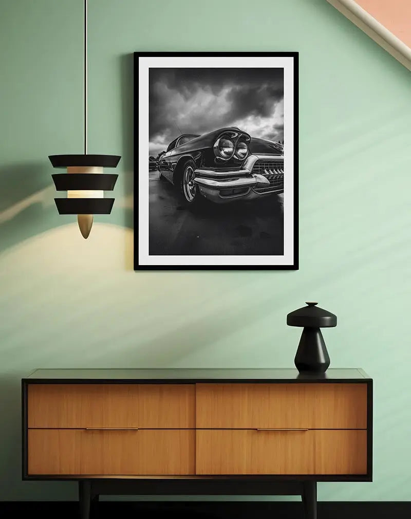 A stunning black and white photograph of a vintage classic car with dramatic clouds in the background. This retro wall art captures the essence of timeless automotive design. Perfect illustration for car enthusiasts or lovers of classic style